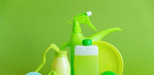 7 Non-Toxic Natural Cleaning Products reusable containers and crumpled bottle with kitchen utensils