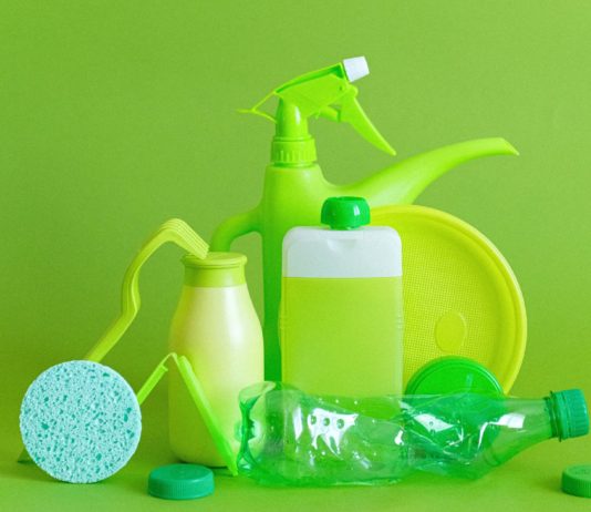 7 Non-Toxic Natural Cleaning Products reusable containers and crumpled bottle with kitchen utensils