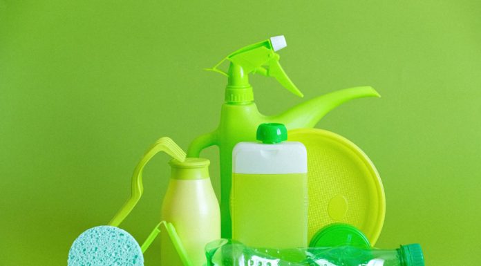 7 Non-Toxic Natural Cleaning Products reusable containers and crumpled bottle with kitchen utensils