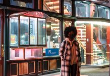 Lockdowns May Prevent The Virus From Naturally Weakening stylish black woman in checkered coat on urban pavement